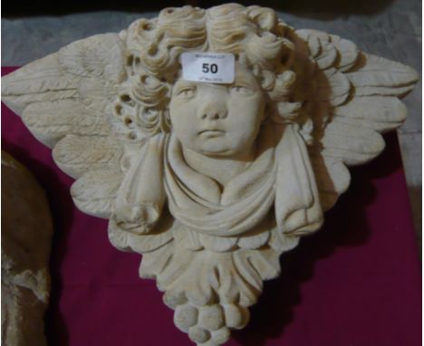 A reconstituted stone wall mounted cherubs face planter, 50cm x 28cm