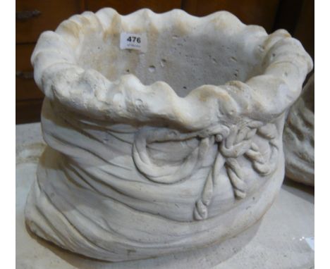 A small sack shaped reconstituted stone planter