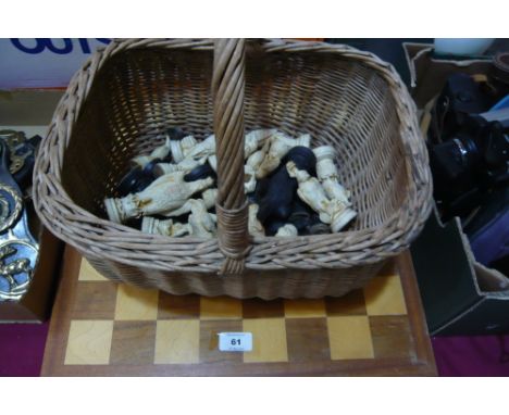 Wicker basket containing chess pieces, chess board