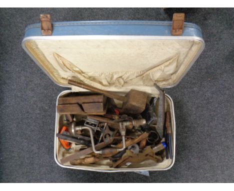 A suitcase containing a quantity of vintage hand working tools to include brace, planes, mallet, together with a three in one