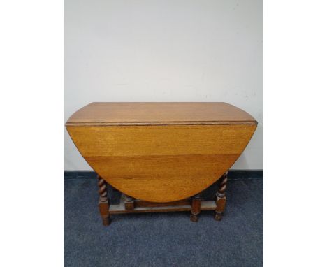 An Edwardian oak barley twist gate leg table 