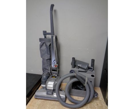 A Kirby Micron Magic upright vacuum with a large quantity of accessories  