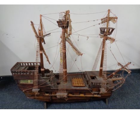 A hand built wooden model of a three masted galleon on stand  