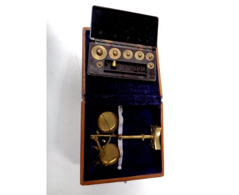 A miniature set of brass balance scales in a fitted box together with a set of miniature weights in a Bakelite case by W and 