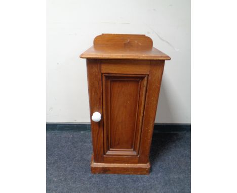 An antique pine bedside cabinet with ceramic handle 