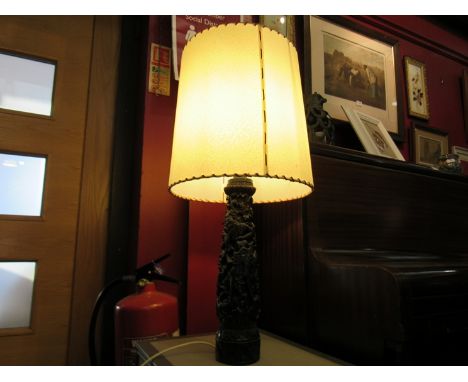 An Indian carved wood lamp base with shade