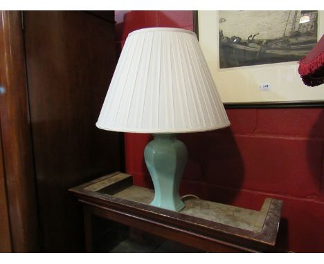 An Oriental style table lamp, jade coloured base with a cream pleated shade