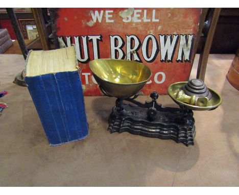 A set of cast iron scales with brass pans and weights and a Mrs Beetons Household Management book