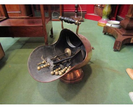 A copper helmet coal scuttle with fire tools