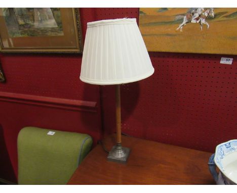 A mahogany and metal table lamp with cream shade
