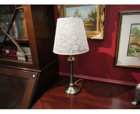 A bronzed metal table lamp with cream shade