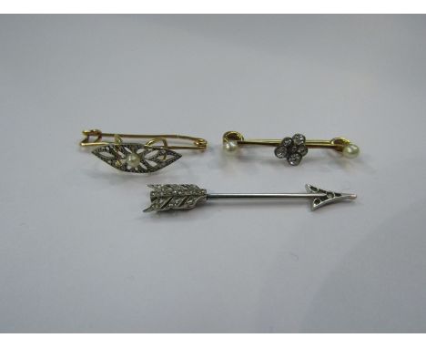 A diamond set "arrow" tie pin, 3.8cm long, 1.8g unmarked with two diamond and pearl bar brooches, one as a pansy, unmarked, 2