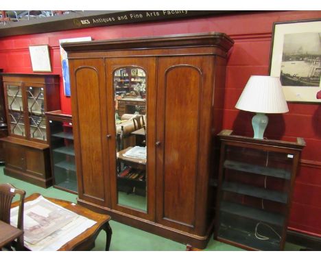 A late Victorian wardrobe with central mirrored door opening to reveal shelf and drawer interior, hanging cupboard to either 