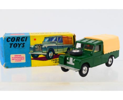 Corgi - A boxed Land Rover 109" in dark green with cream canopy and early style metal tow hook. # 438. It appears in Very Goo