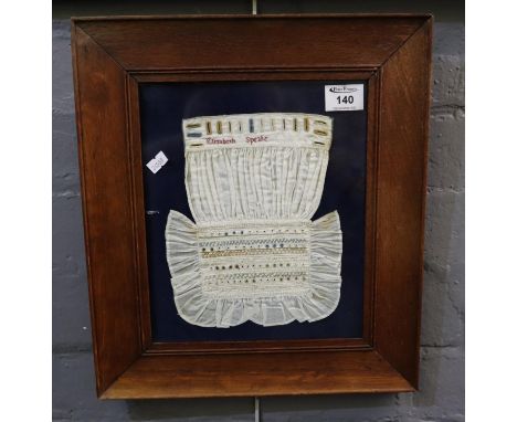 Embroidery sample cotton item with practice button holes and different styles of embroidery marked 'Elizabeth Speake', framed