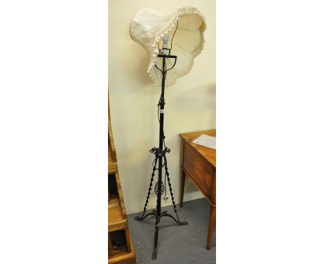 Wrought iron standard lamp with shade, having swirl and scrolled foliate decoration on tripod base.(B.P. 21% + VAT) 
