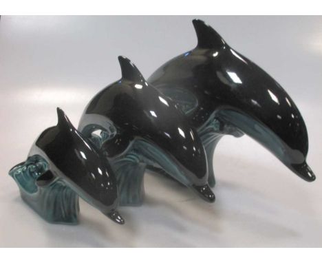 A graduated set of three Poole Pottery dolphins, together with a St Ives Pottery stoneware jar and cover, two Winchcombe Pott