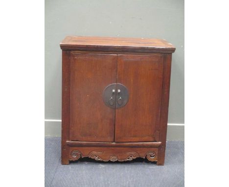 A 20th century Chinese hardwood two door cupboard, inside one fixed shelf with two drawers 84 x 74 x 45cm