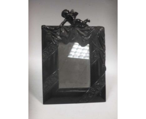 An early 20th century moulded composition framed mirror with putto to the top, easel strut back 18 x 20cm