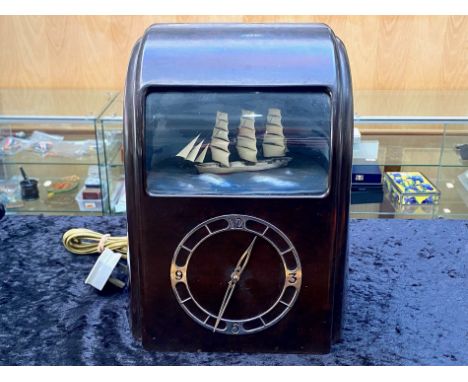 Art Deco Vitascope Rocking Ship Electric Automaton Clock, the brown bakelite case with silvered dial and window showing a sai