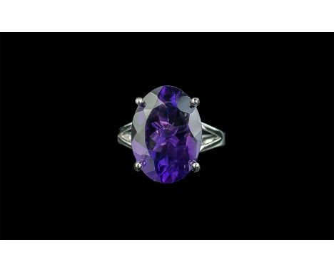 Amethyst Solitaire Ring, an 11ct oval cut amethyst of a rich, noble purple shade, set in an open mount of rhodium vermeil and