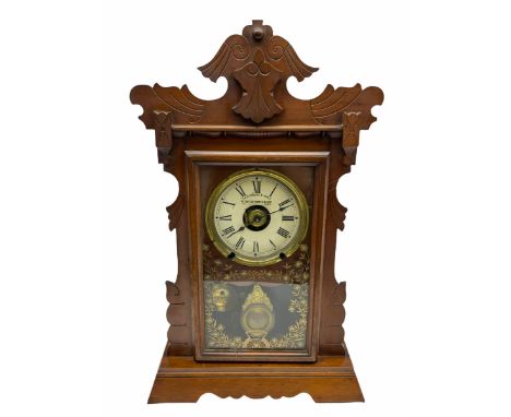 An early 20th century spring driven alarm clock in the style of an American  �gingerbread� shelf clock, rectangular wooden ca