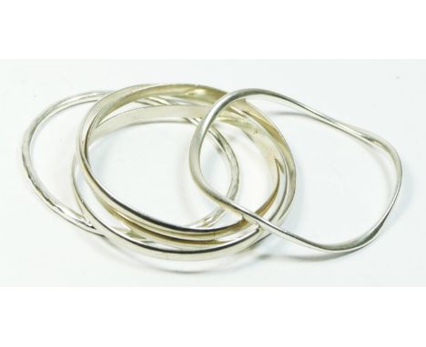 A silver interlocking bangle, London 1991, 7cm diameter, and two other silver slave bangles, 85gm 