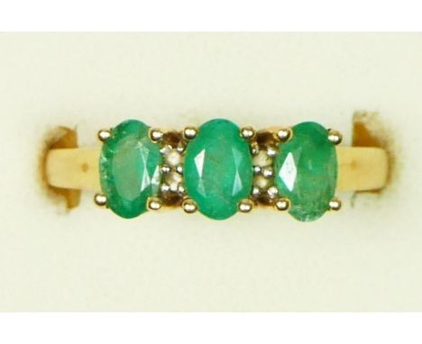 A 9ct gold emerald three stone ring, diamond points between, O 1/2, 3.6gm 