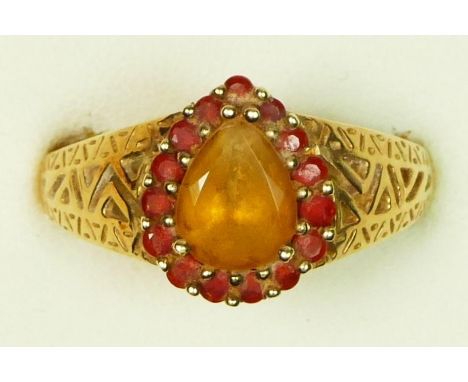 A 9ct gold citrine and red gemstone cluster ring, pierced shoulders, U, 3.8gm 