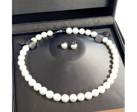 A string of uniform cultured pearls, on a silver snap clasp, by Sherry Jewellery, boxed, together with a pair of cultured pea