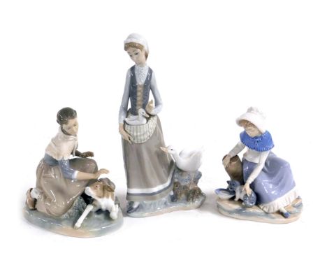 A Lladro porcelain figure of a kneeling woman and calf, further figure group of a lady with a duck and ducklings, and a Nao f