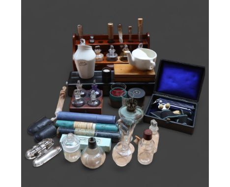 A antique teak laboratory rack with fitted drawer and a selection of clear glass apothecary bottles and test tubes, some labe