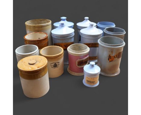 A group of ceramic apothecary jars, several with gold gilt period labels and associated lids, together with a selection of st
