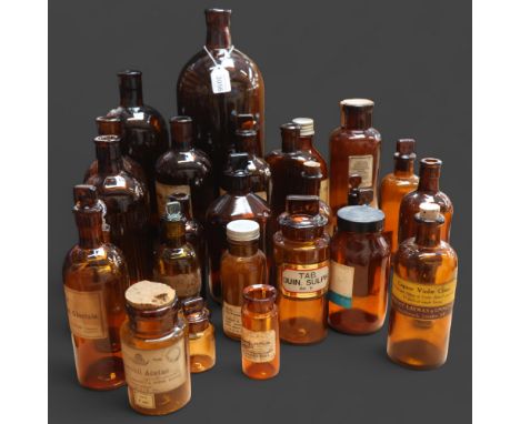 A large quantity of amber glass apothecary bottles, mixed sizes and styles, some stoppers present, some corked, varying label