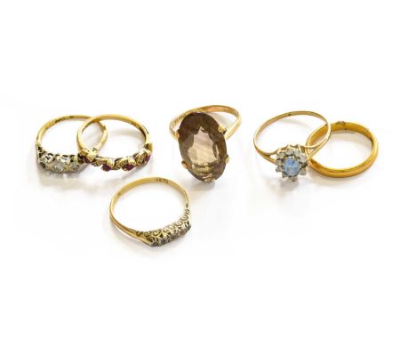 A 22 carat gold band ring, finger size L; and five gem set rings including a smoky quartz example, a ruby and diamond example