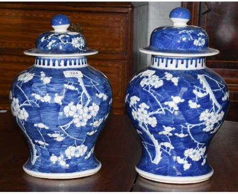 A pair of Chinese baluster form blue and white porcelain vases and covers, Kangxi reign marks but 20th century, painted in un