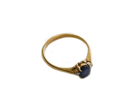 A sapphire and diamond three stone ring, the oval cut sapphire flanked by round brilliant cut diamonds, in claw settings, to 