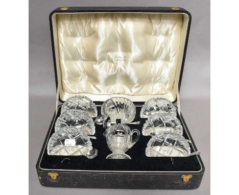 A George V cased silver and cut glass strawberry set comprising: sugar bowl, cream jug, six bowl, six spoons and sugar ladle,