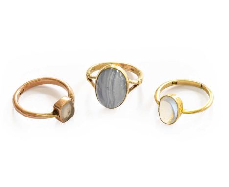 A moonstone ring, stamped '18', finger size J; a 9 carat gold banded agate ring, finger size I1/2; and an intaglio ring, stam