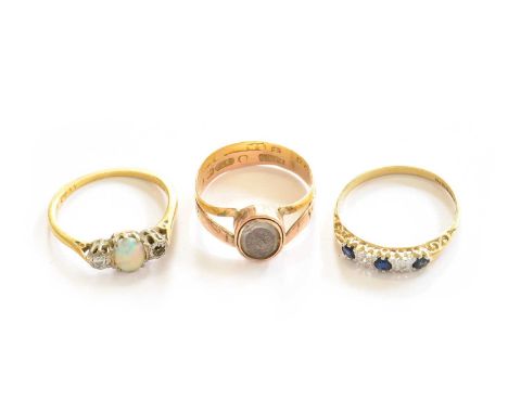 A 9 carat gold mourning ring, finger size N; a 9 carat gold sapphire and diamond ring, finger size O; and an opal and diamond