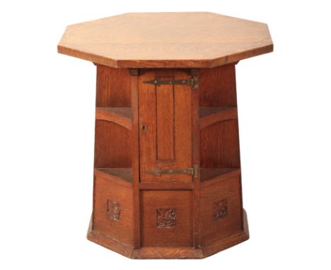 AN ARTS AND CRAFTS OAK OCTAGONAL BOOK OR OCCASIONAL TABLE IN THE STYLE OF HEALSwith two parallel side doors (each with key) s