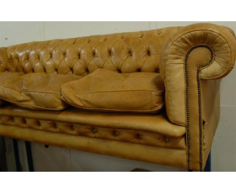 A large light tan leather buttonback and metal studded Chesterfield, together with matching footstool (2) 