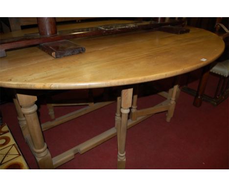 A light oak drop leaf wake table having double gateleg action