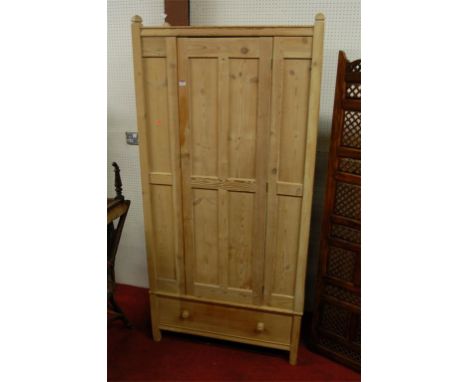 A panelled pine single door wardrobe, having single long lower drawer 