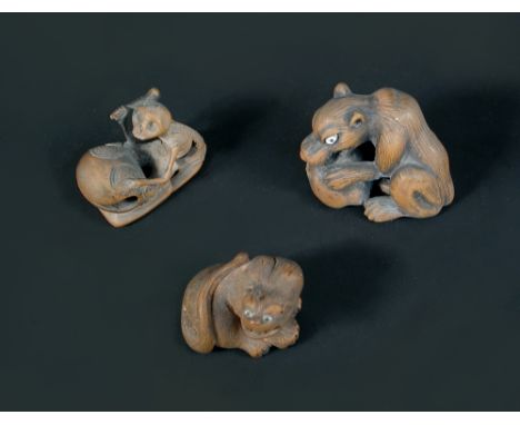 A 19th century wooden netsuke carved as a seated tiger snarling, its eyes inlaid with jet pupilled ivory, 3.5cm (1.3 in) wide