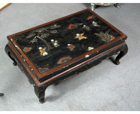 An inlaid black lacquer low table, the red edged rectangular top inlaid with children playing within a fenced garden, the scr