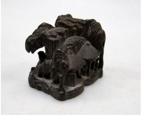 A 19th century wooden netsuke carved as a mountainous village with figures on a bridge and amongst trees, signed Naganobu or 