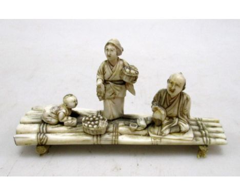 Toshikazu', an early 20th century ivory raft group, the sectional figures of the father seated with his pipe in hand on the b