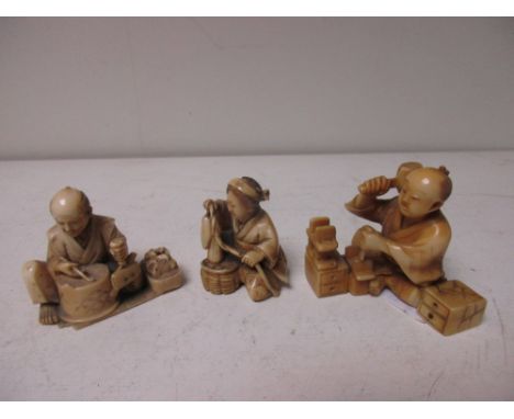 Three late 19th/early 20th century ivory seated crafts people, the man seated by a drum shaped box tobacco pipe in hand holds