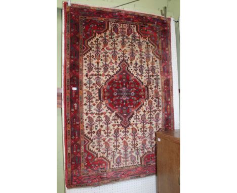 AN IRANIAN WOVEN WOOLEN FLOOR CARPET having central lozenge &amp; stylised flowers, within a triple guard border,&nbsp;103cm 